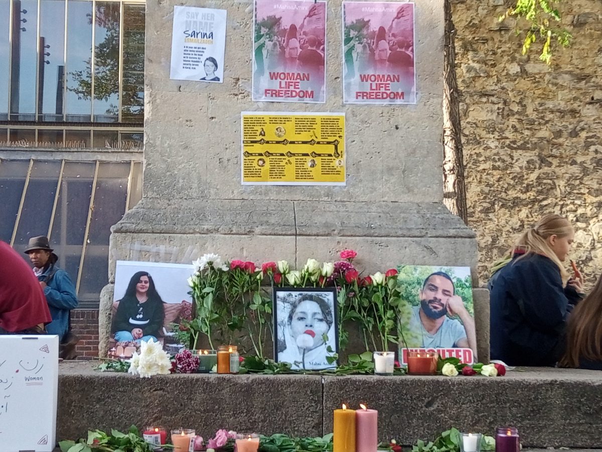 Posters, flowers and candles laid in memory of Mahsa Amini in Bonn Square, Oxford