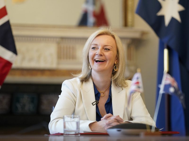 picture of Liz Truss at a desk, laughing