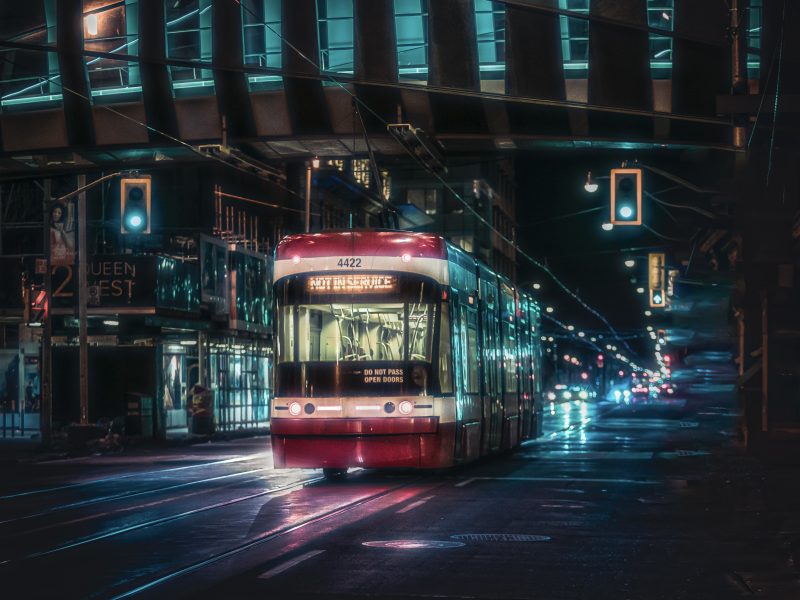 A Red Streetcar Moving on the Road During Night Time