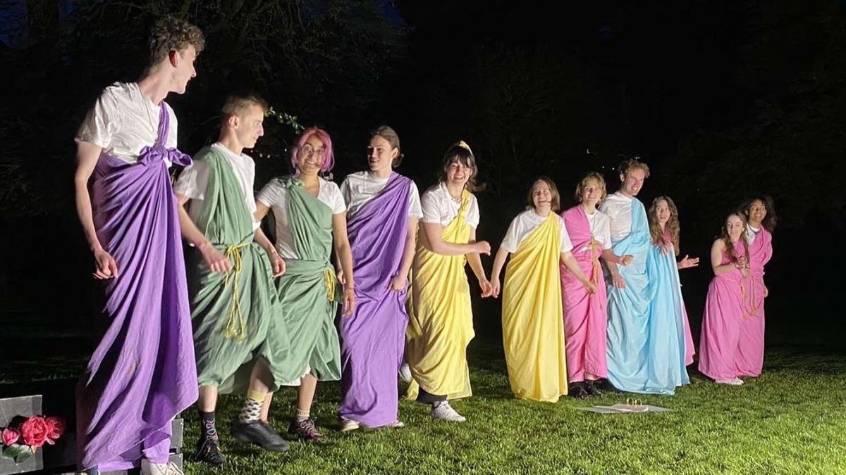 A line of actors in different coloured togas