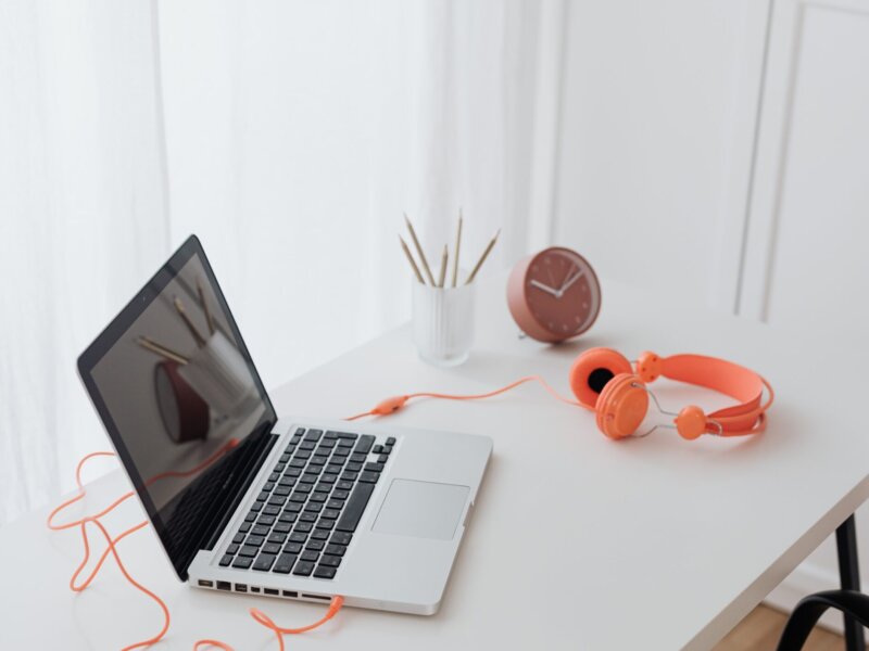 A photo of laptop and headphones on a desk.