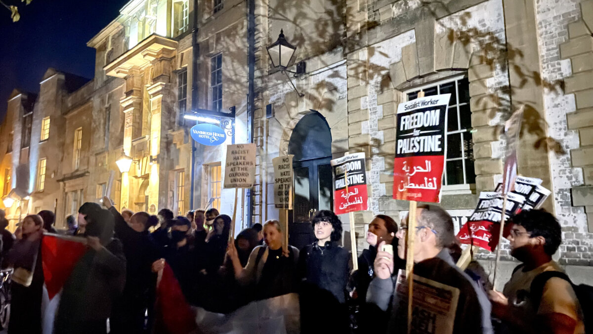Protestors outside the Oxford Union carrying banners that state 'No Racist Hate Speakers at the Oxford Union' and 'Freedom for Palestine'.
