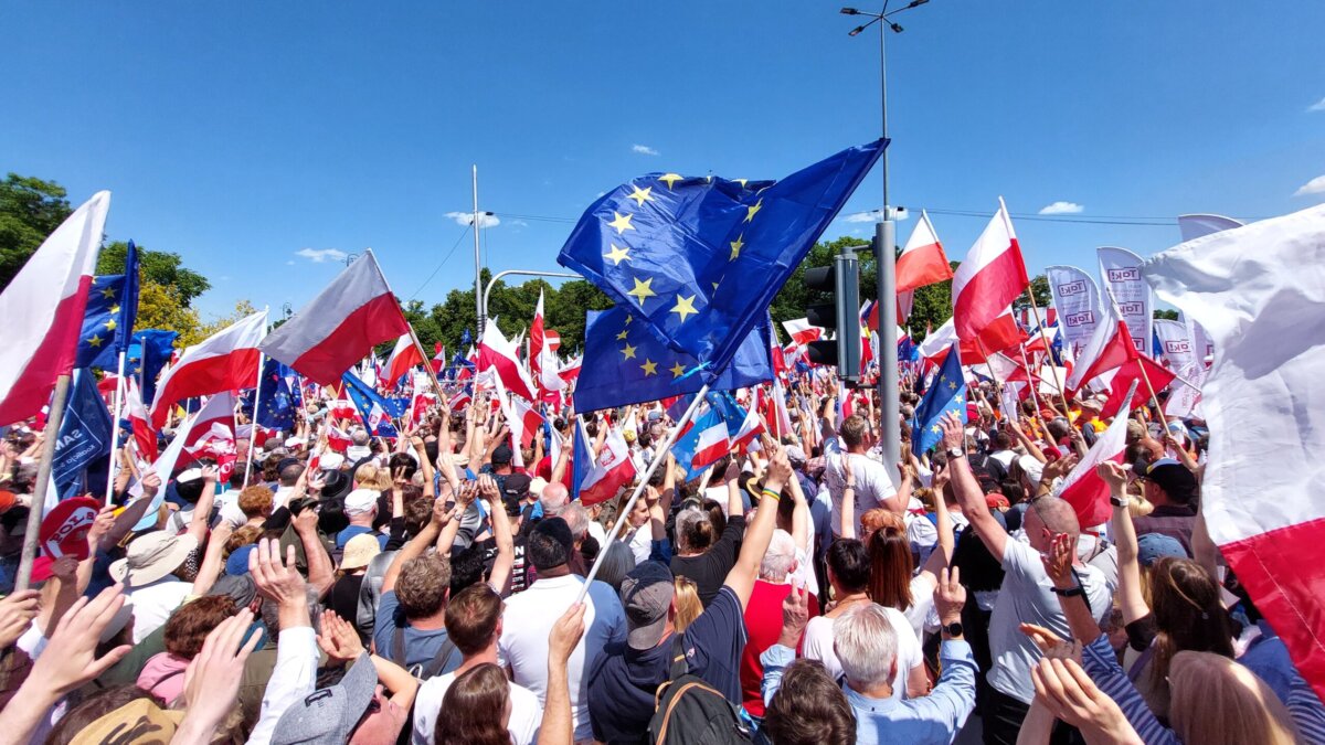 Participants at a Polish opposition rally wave Polish and EU flags.