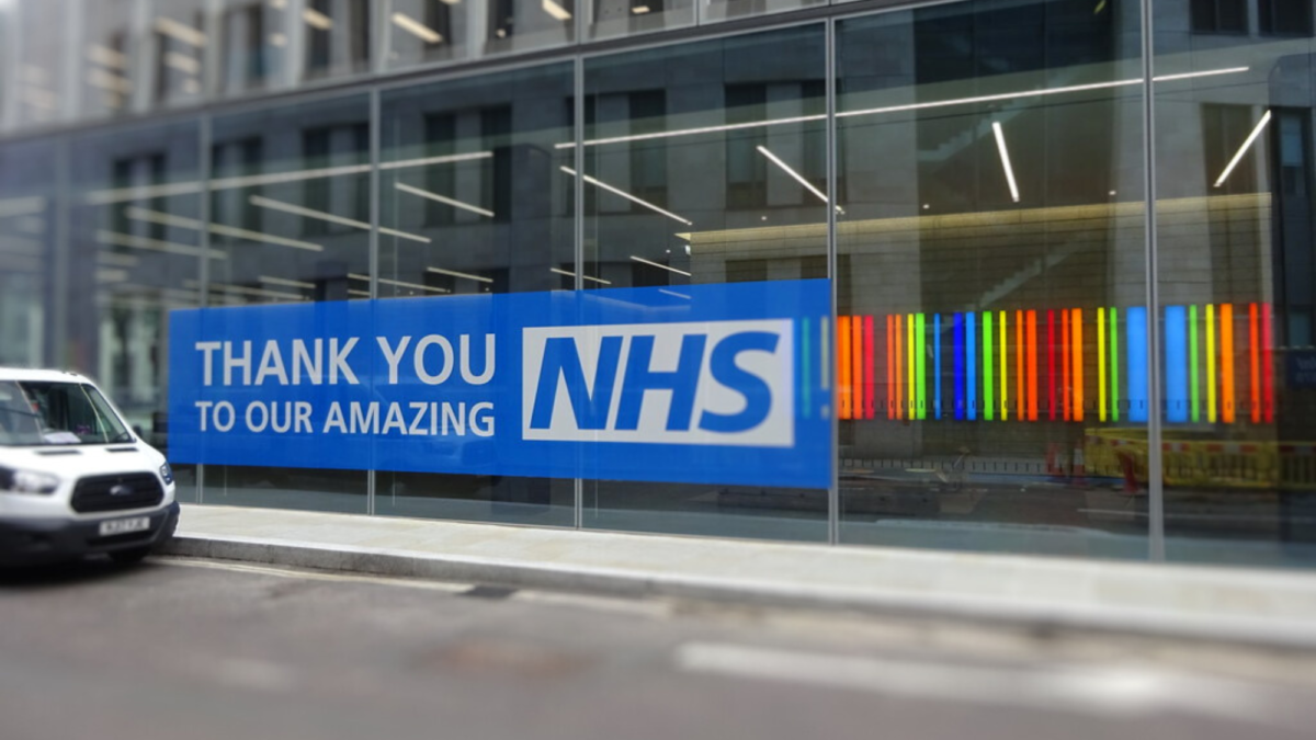The image shows the front of a building with a blue banner reading ‘Thank you to our amazing NHS’