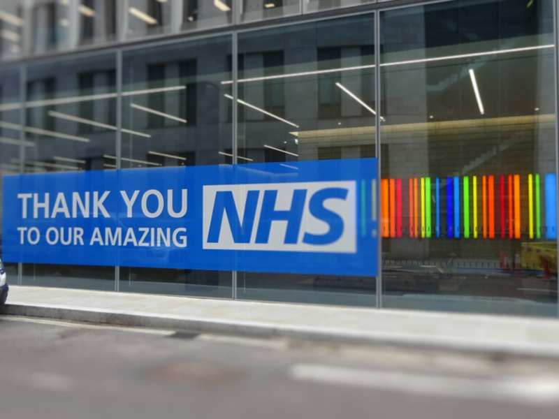 The image shows the front of a building with a blue banner reading ‘Thank you to our amazing NHS’