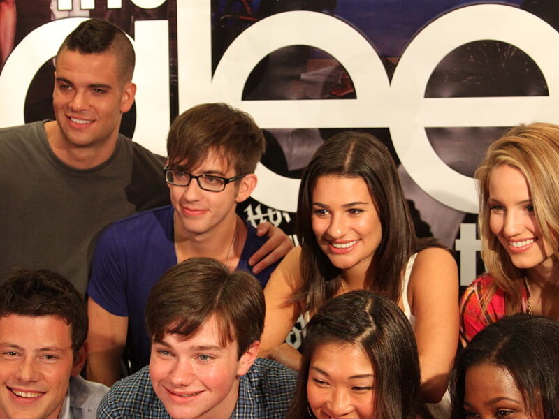 A photograph of eight "Glee" cast members. On the top row from left to right, Mark Salling, Kevin McHale, Lea Michelle, and Dianna Agron. On the bottom row from left to right, Cory Monteith, Chris Colfer, Jenna Ushkowitz, and Amber Riley.
