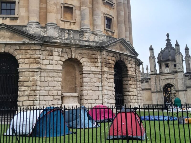 A picture of a number of tents set up on the lawn in front of the Radcliffe Camera as part of a further development in the OA4P encampments.