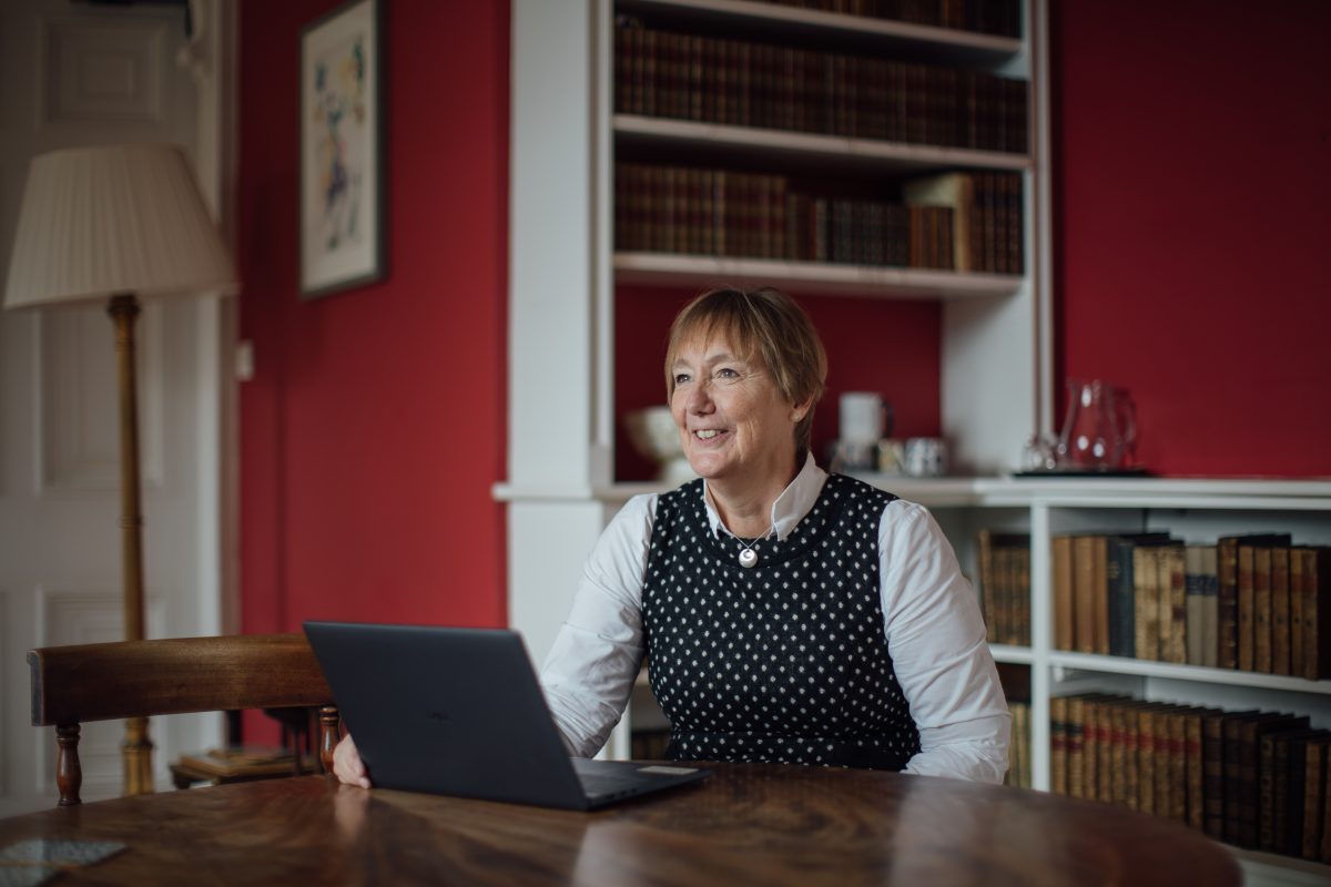 Catherine Royle sitting at a desk, looking beyond the camera