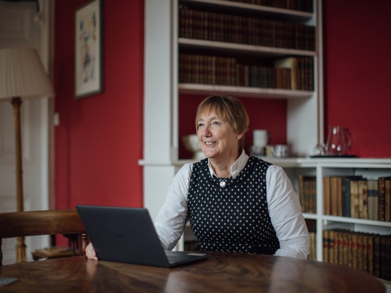 Catherine Royle sitting at a desk, looking beyond the camera