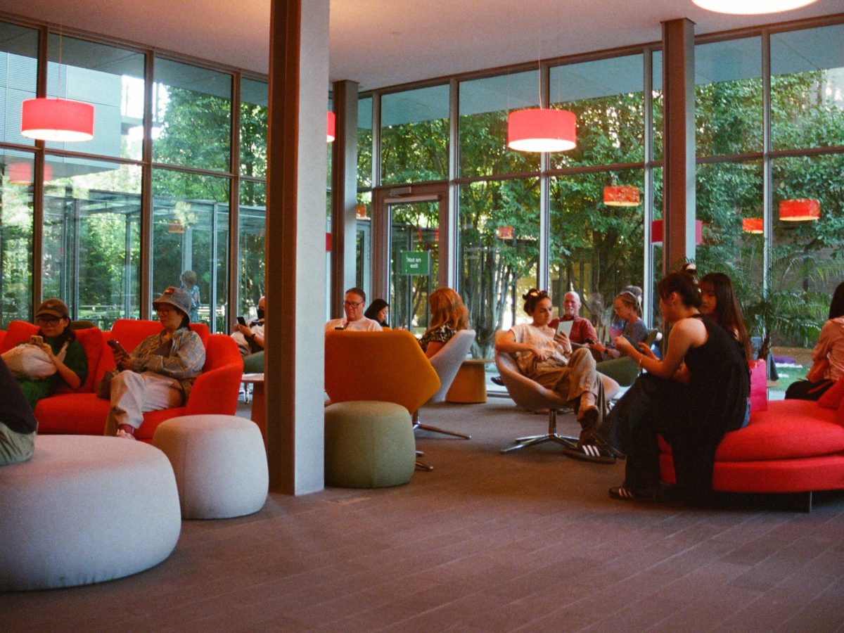 A picture of people in a library common room. Everyone is looking at their phones.