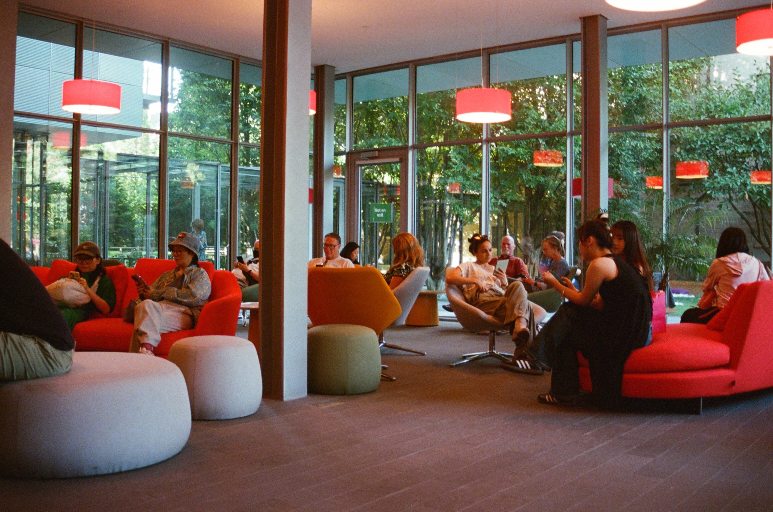 A picture of people in a library common room. Everyone is looking at their phones.