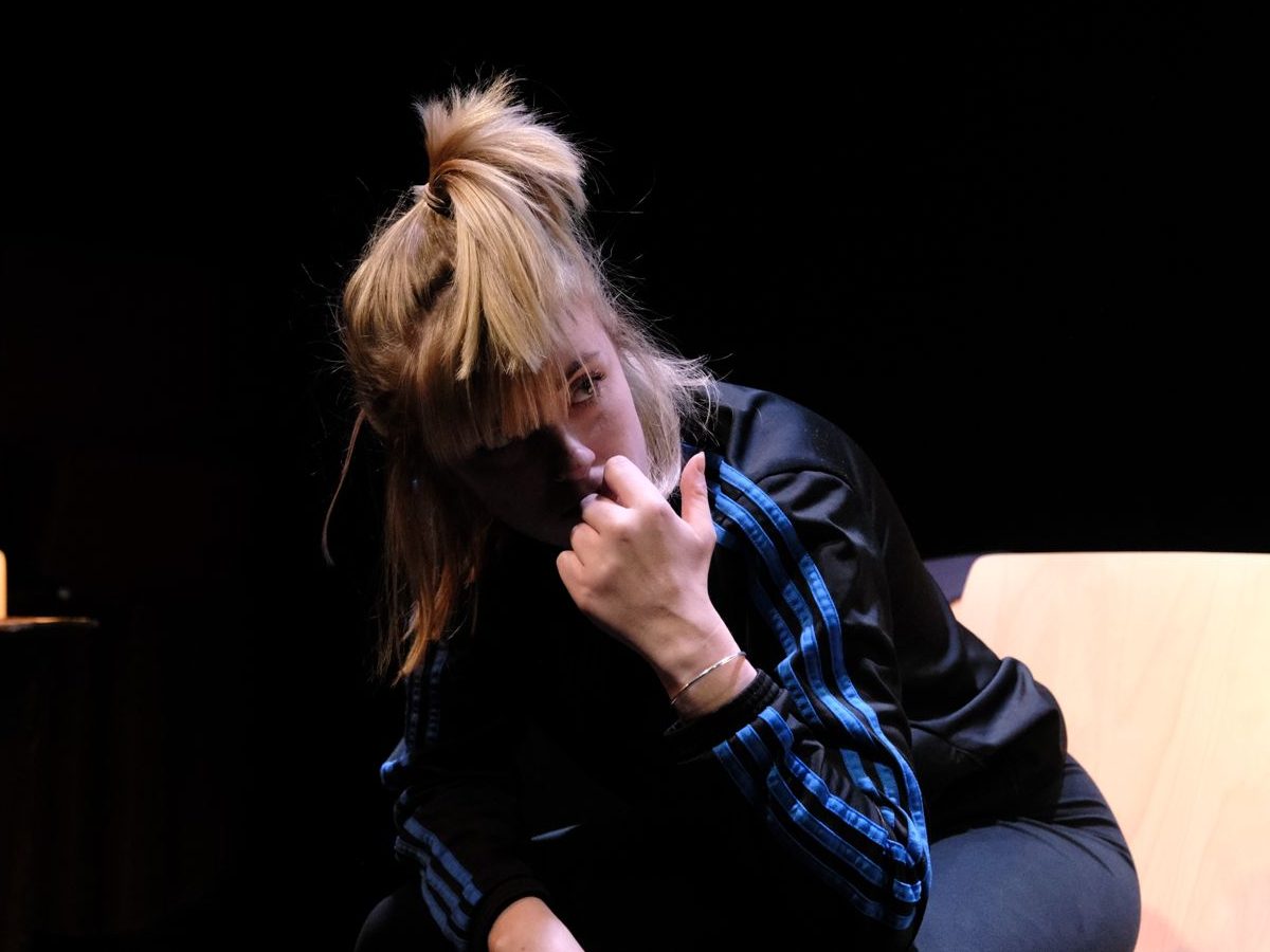 A photo of a cast member sat leaning forward on set