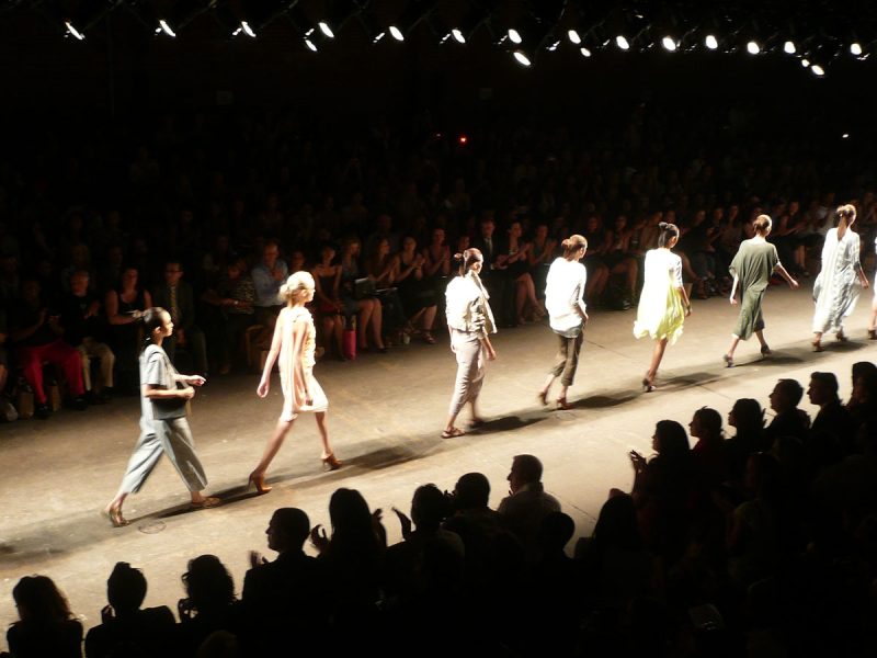 A photo of models walking across a runway at a fashion show