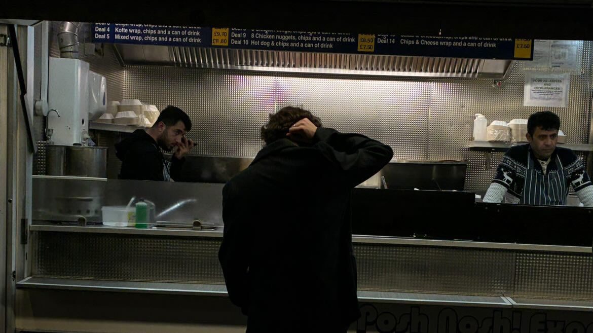 A typical kebab van with a customer standing outside.