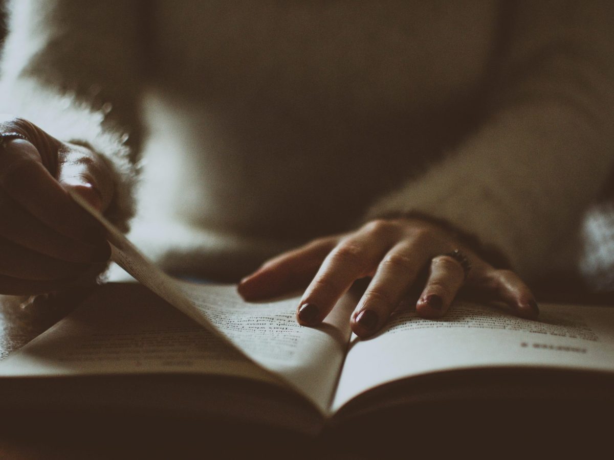 Photo of somebody alone flipping a book.