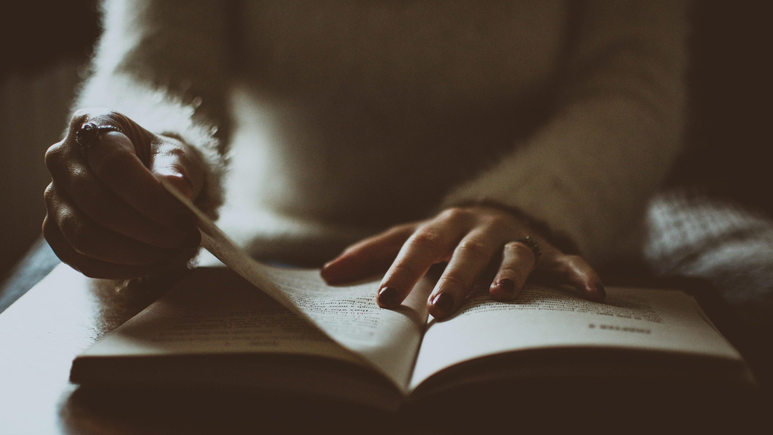 Photo of somebody alone flipping a book.