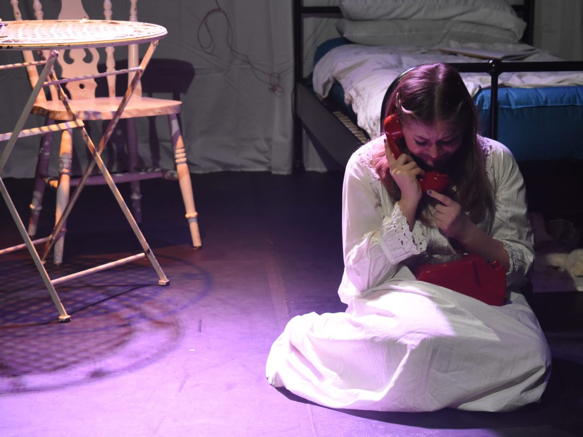 The lead actor of La Voix, Grace Gordon, sits crying holding a telephone.