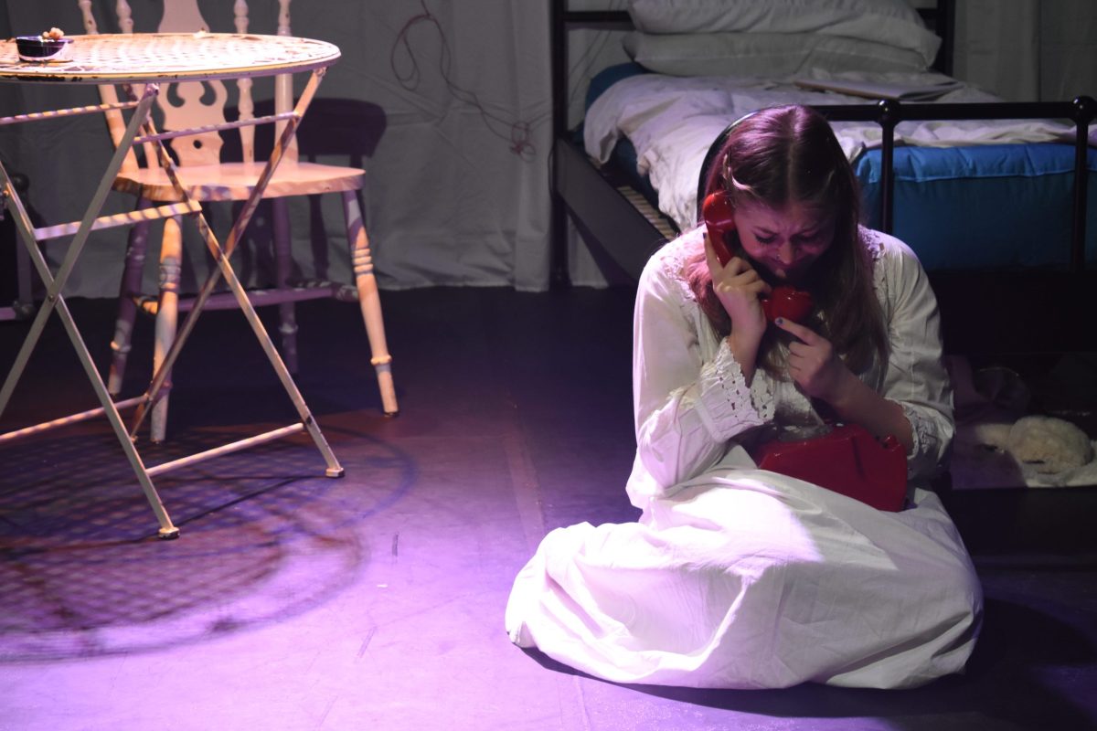 The lead actor of La Voix, Grace Gordon, sits crying holding a telephone.