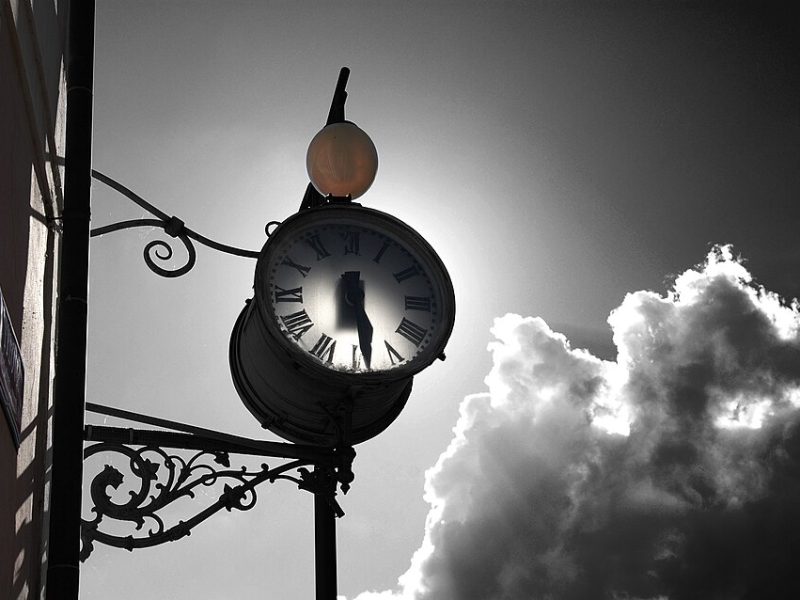 A vintage, old-fashioned black and white clock.