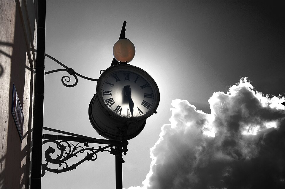 A vintage, old-fashioned black and white clock.