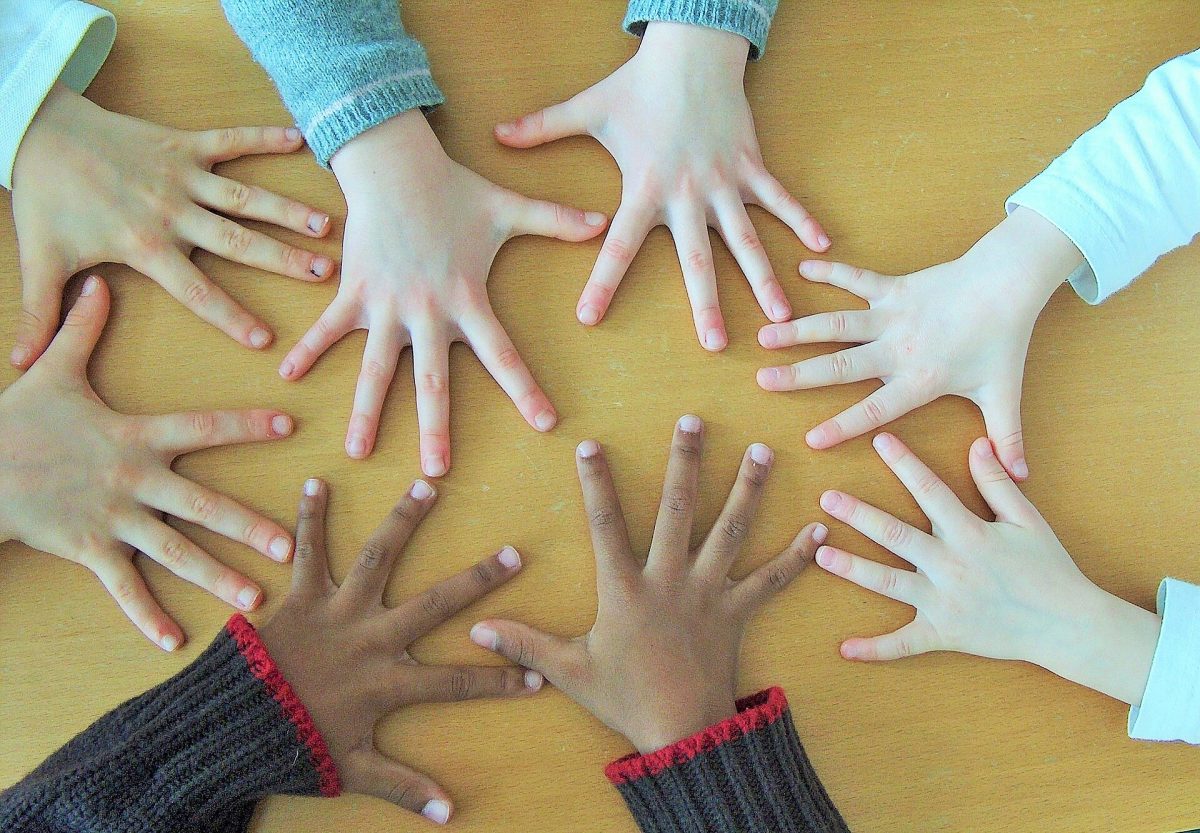 A collection of hands of various skin tones in a circle.