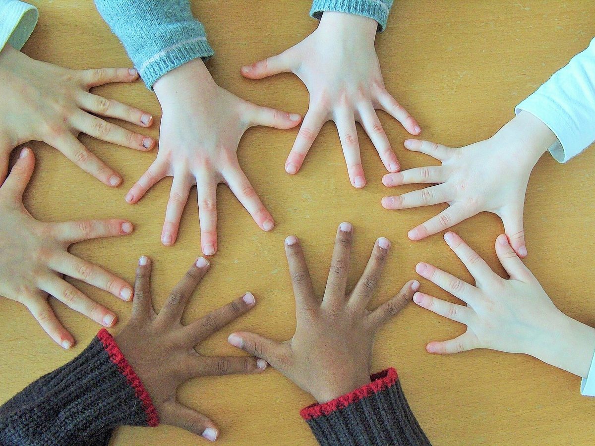 A collection of hands of various skin tones in a circle.