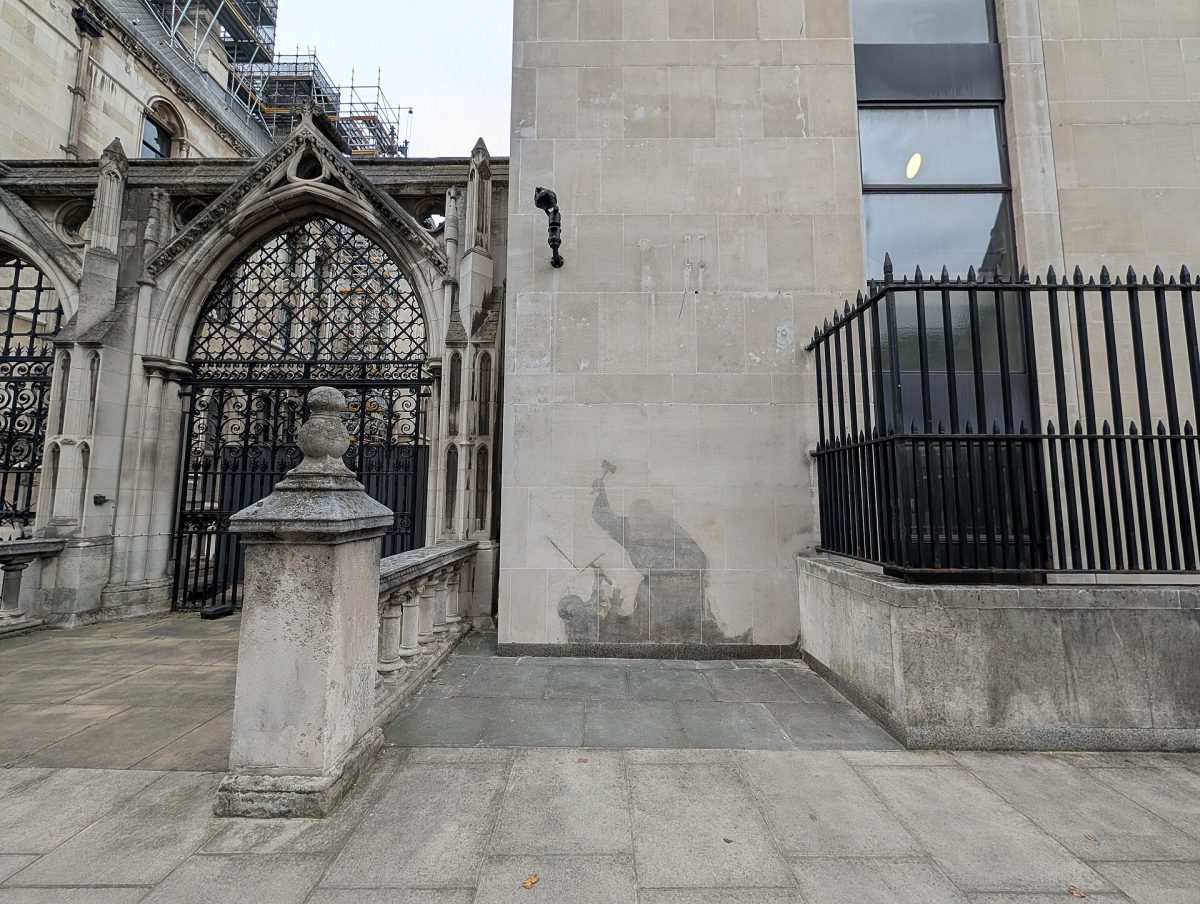 A Banksy stencil showing a judge beating a protester with a gavel on the Royal Courts of Justice in London.