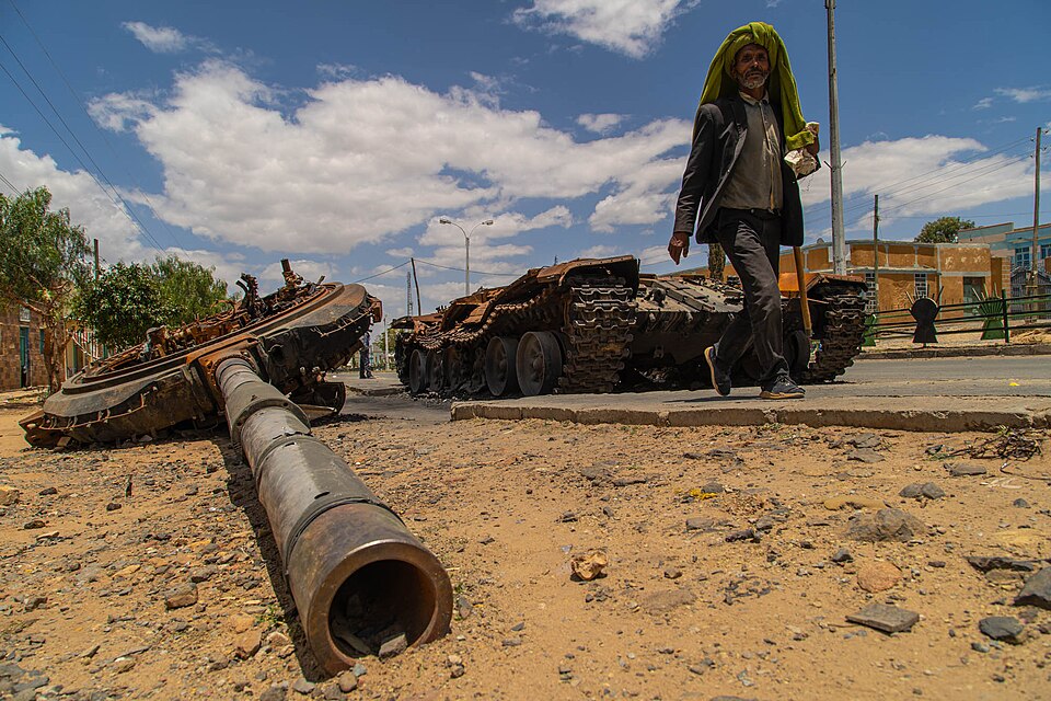 A man walks past a wrecked tank in Tigray Region, 2021.