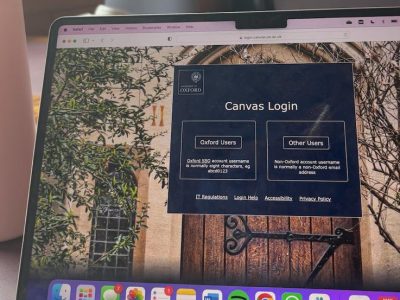 Laptop showing Canvas login page, with a pastel pink waterbottle on the left