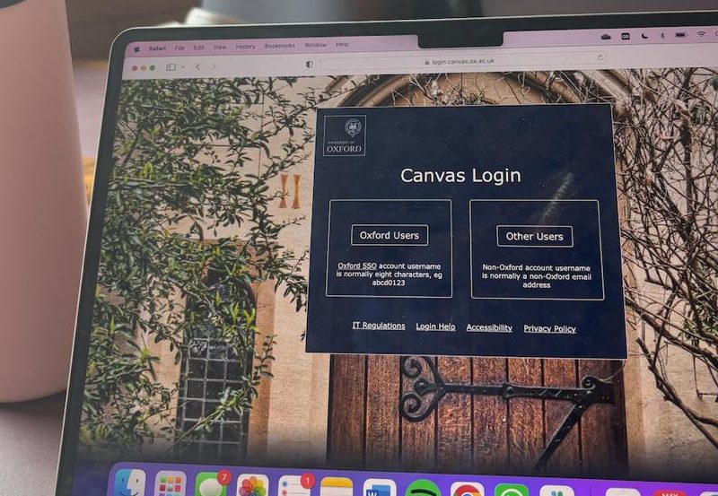 Laptop showing Canvas login page, with a pastel pink waterbottle on the left