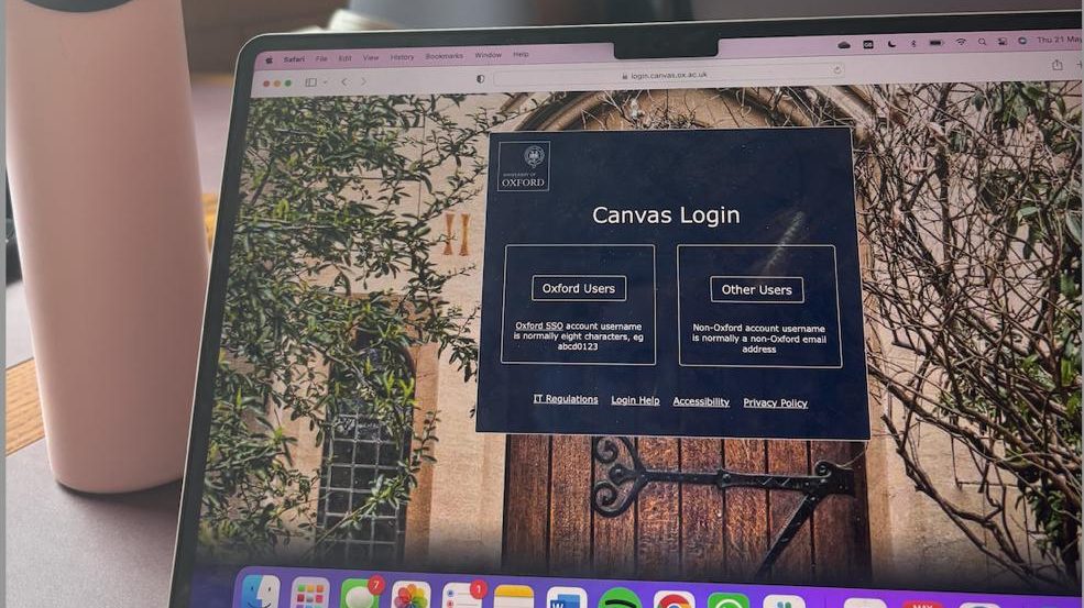 Laptop showing Canvas login page, with a pastel pink waterbottle on the left