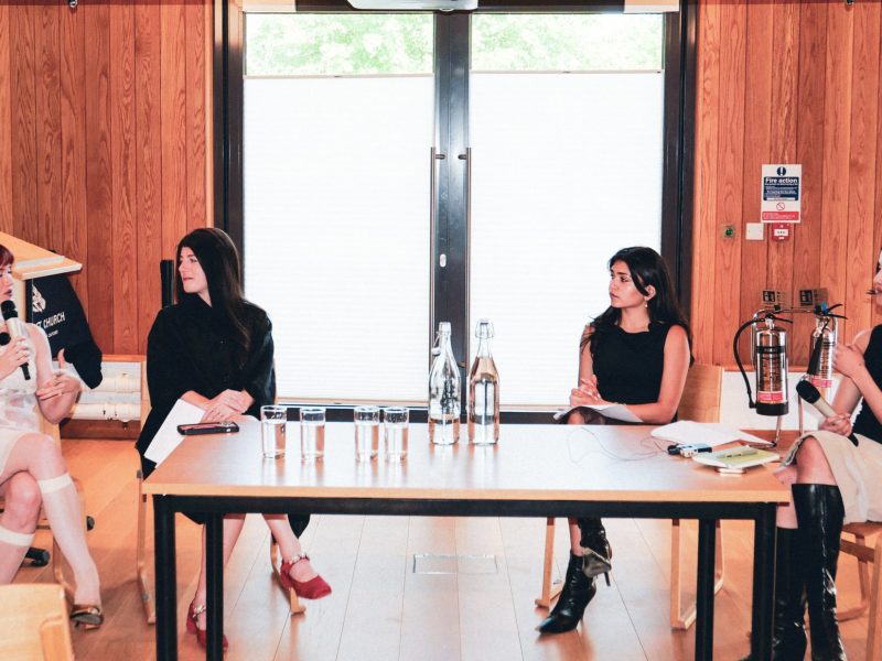 Four women sit at a table talking.