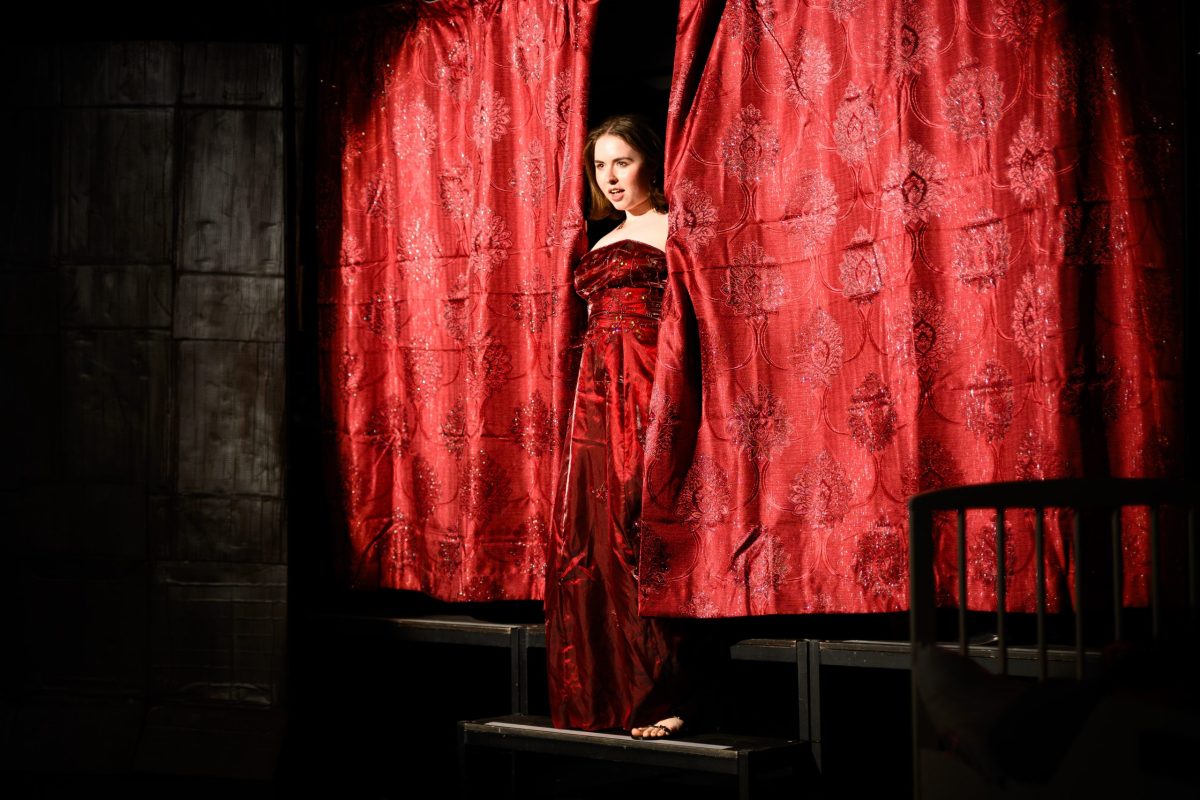 Lady Carla (Genevieve Kidd) pokes out from behind the curtain