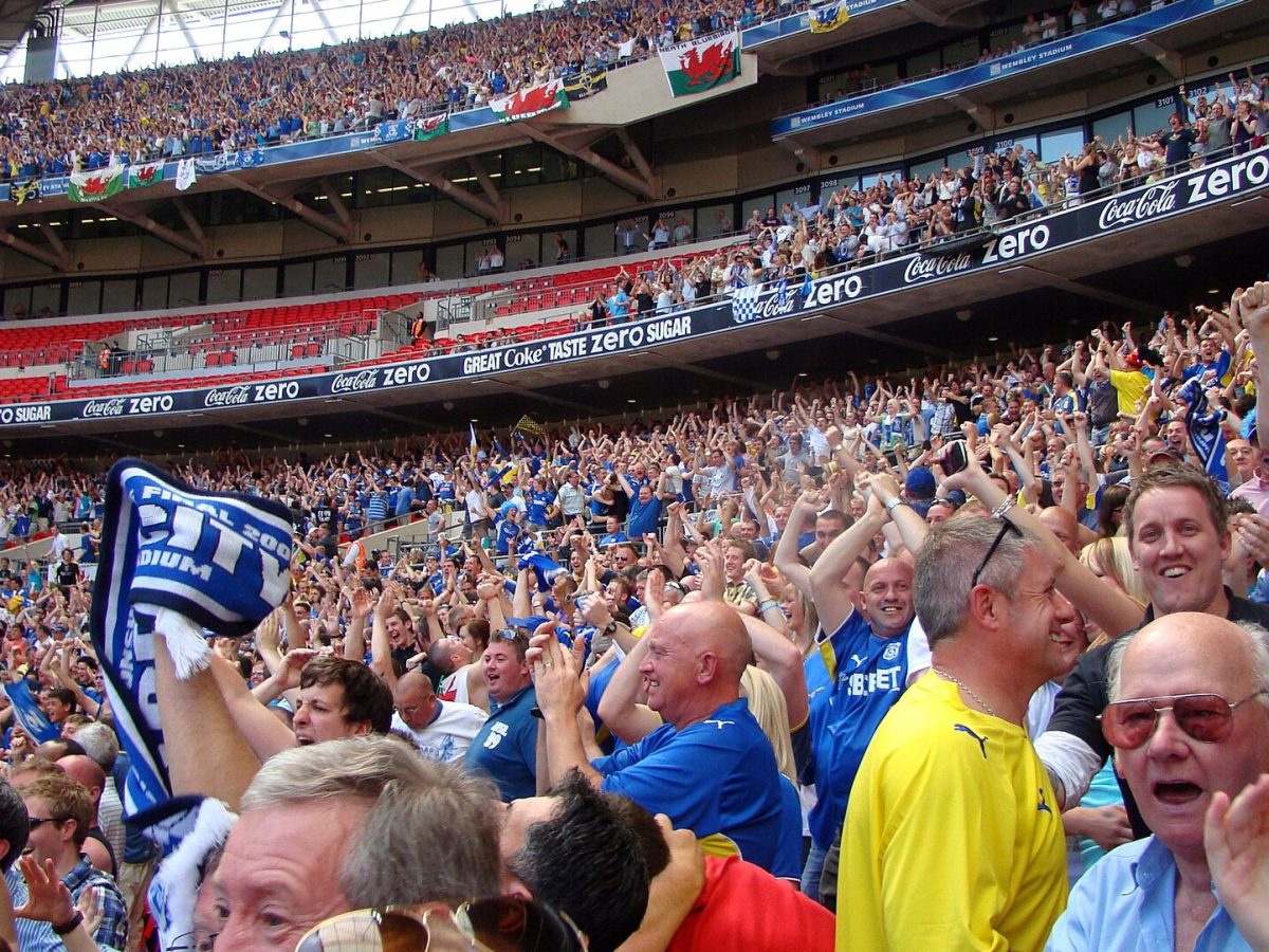 Close-up of football fans celebrating a goal at Wembley Stadium