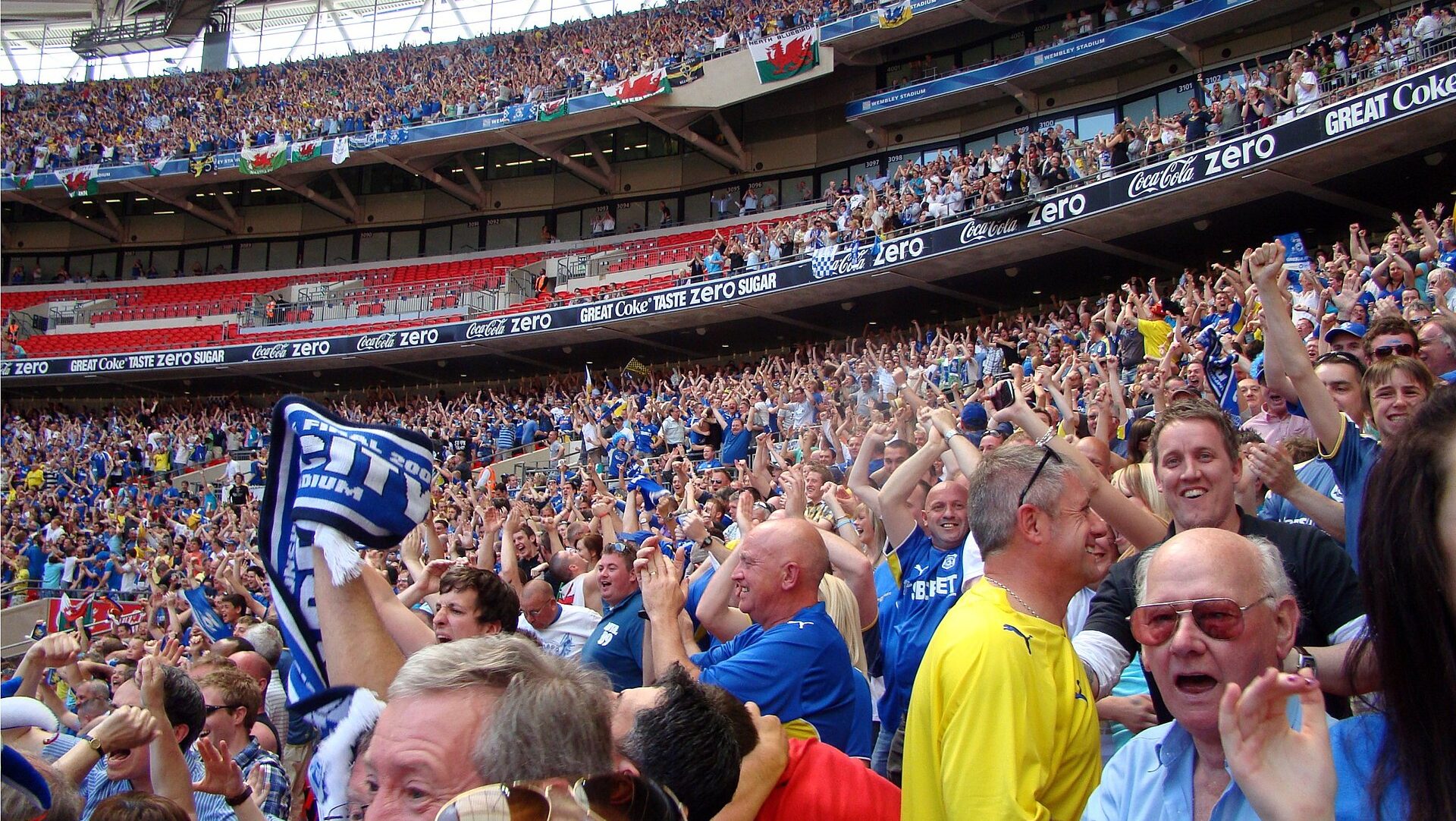 Close-up of football fans celebrating a goal at Wembley Stadium