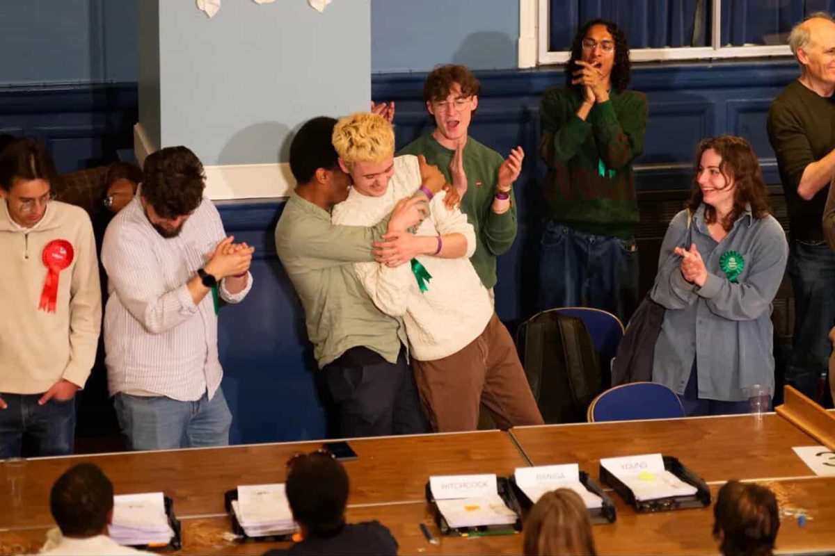 Green candidate Alfie Davis in an embrace with jubilant Green Party members