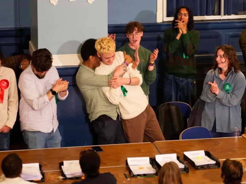 Green candidate Alfie Davis in an embrace with jubilant Green Party members
