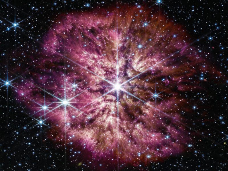 The star Wolf-Rayet 124 (WR124) shines at the centre of an image taken by the NASA/ESA/CSA James Webb Space Telescope. Background stars and galaxies surround WR 124.