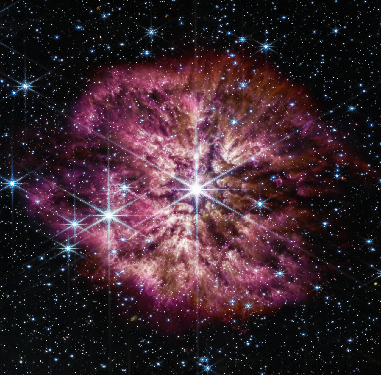 The star Wolf-Rayet 124 (WR124) shines at the centre of an image taken by the NASA/ESA/CSA James Webb Space Telescope. Background stars and galaxies surround WR 124.