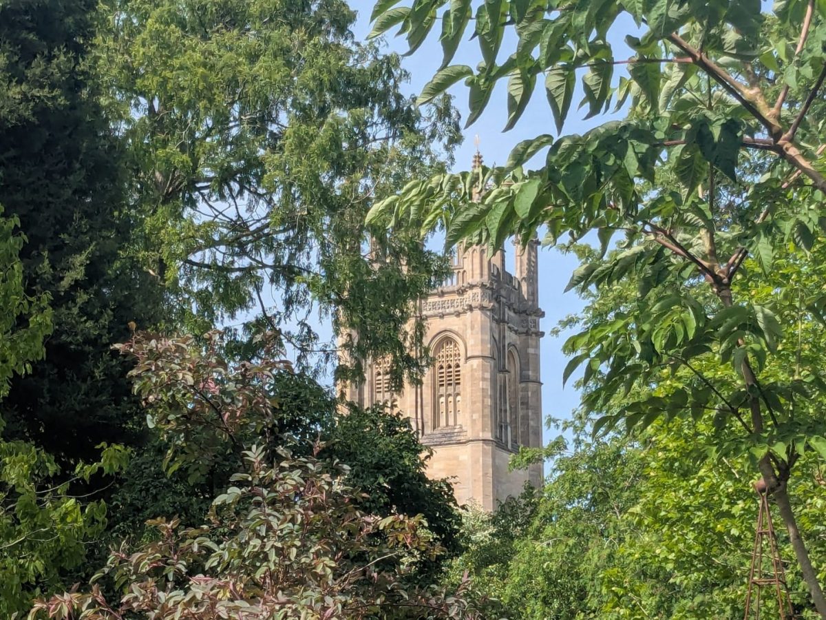 Photo of an Oxford building from a distance, surrounded by trees