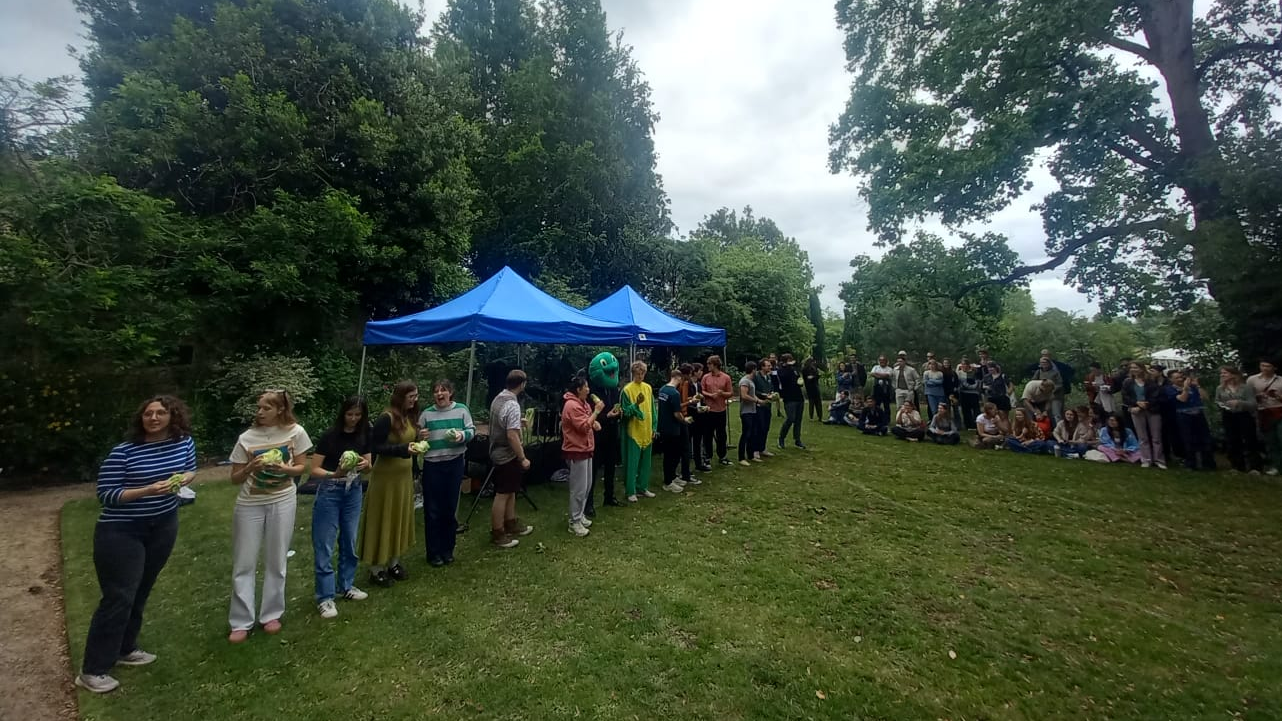A row of students, each holding lettuce.