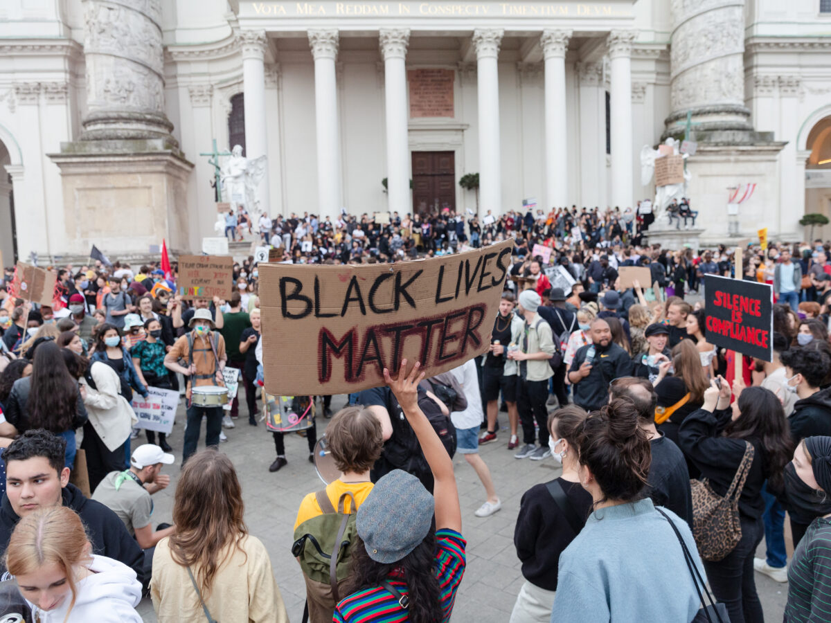 A group of activists in a demonstration for Black Lives Matter, based in front of a building in Vienna.