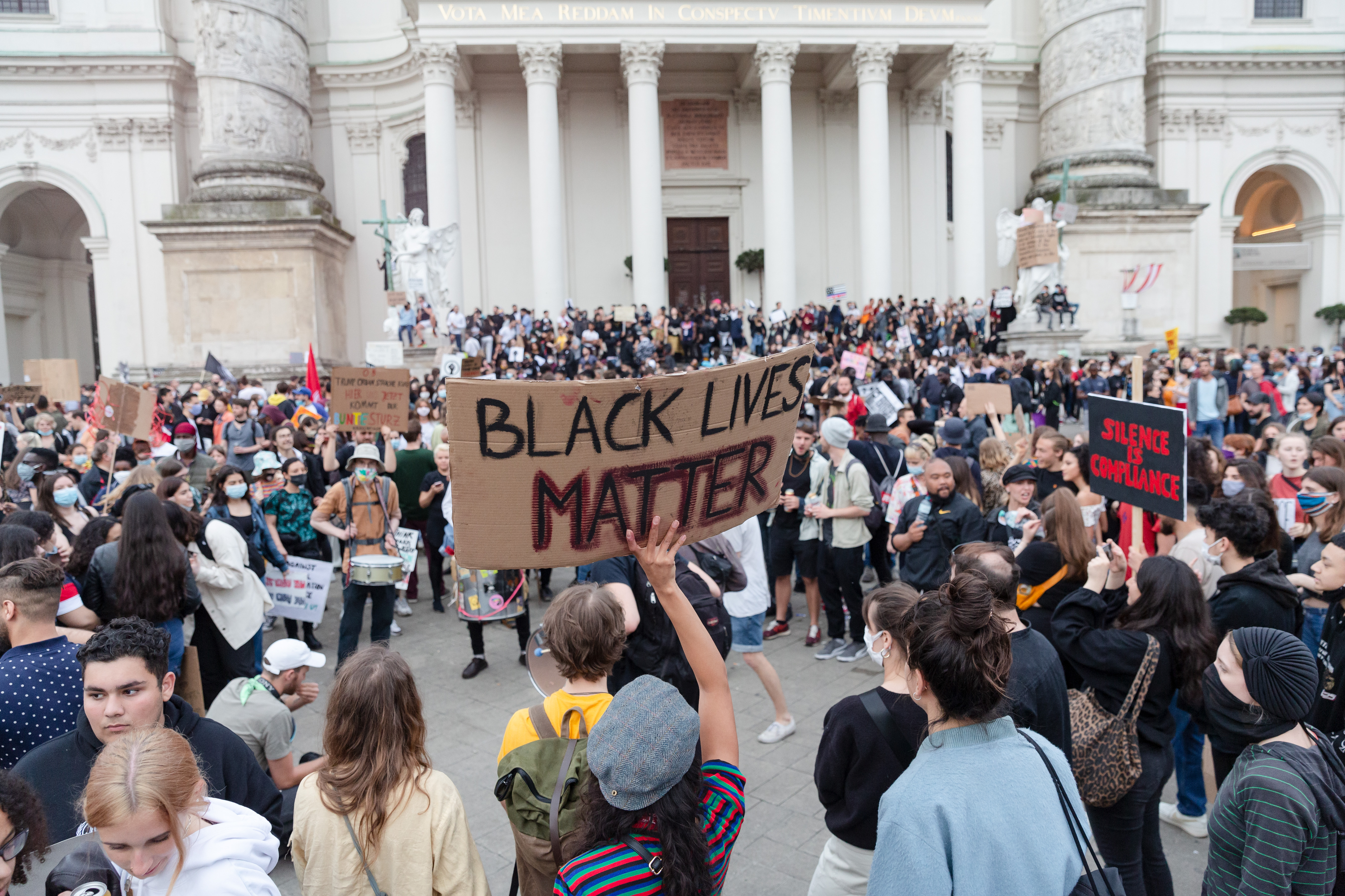 A group of activists in a demonstration for Black Lives Matter, based in front of a building in Vienna.