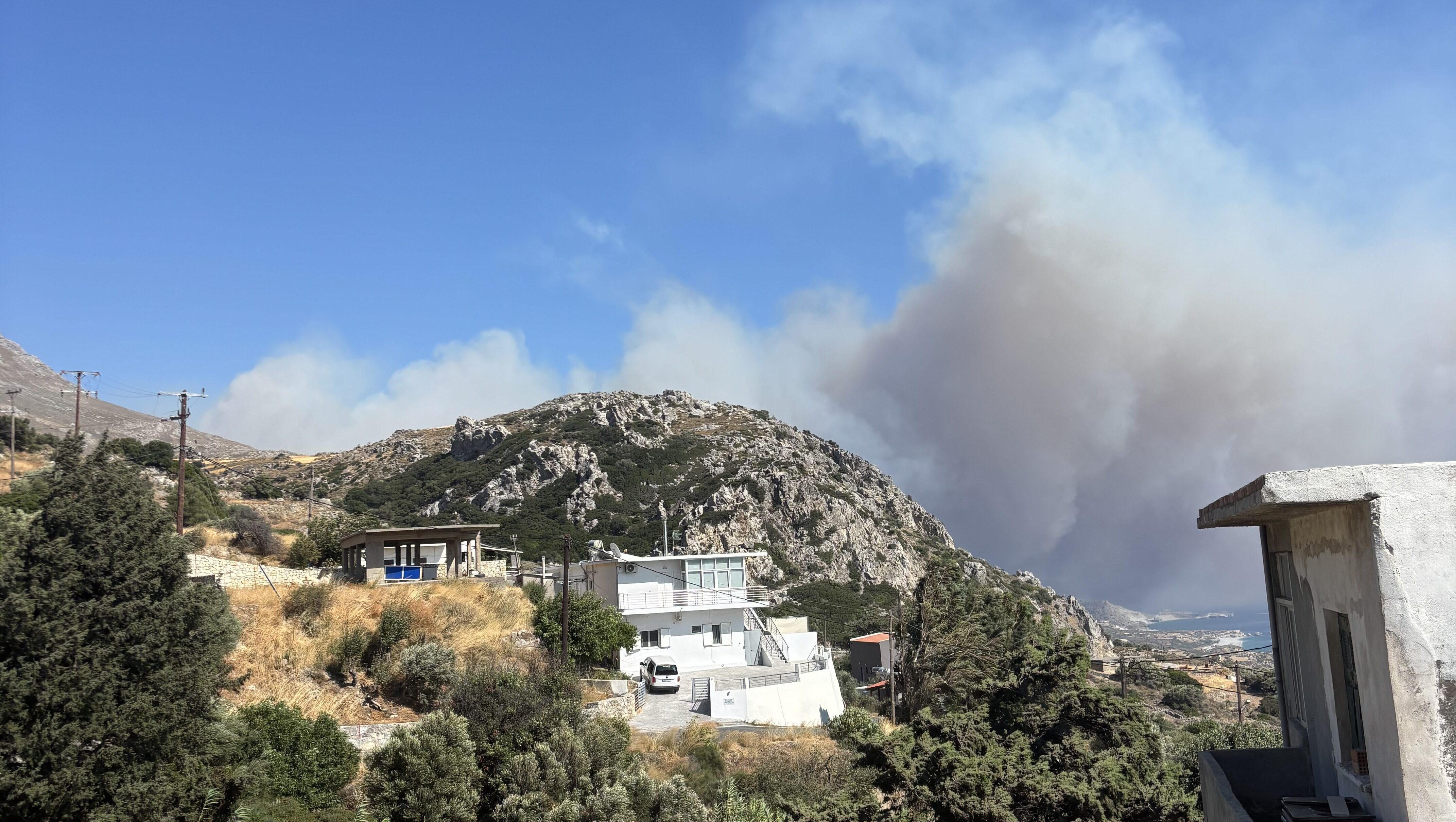 Image of wildfire smoke coming from behind a hill