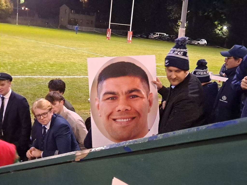 An OURFC fan holds up a poster of Reed Prinsep's face