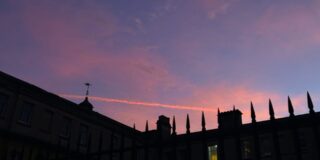 This image shows a picture of a sunset from an Oxford college, with the building in the foreground.