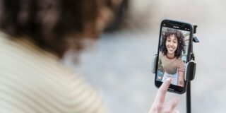 Woman filming herself on a phone, presumably making a TikTok.
