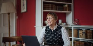 Catherine Royle sitting at a desk, looking beyond the camera