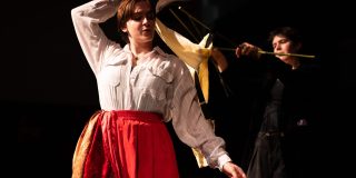 A photo of a cast member in costume, a puppet and a puppeteer