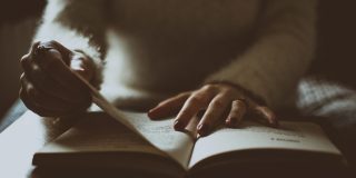 Photo of somebody alone flipping a book.